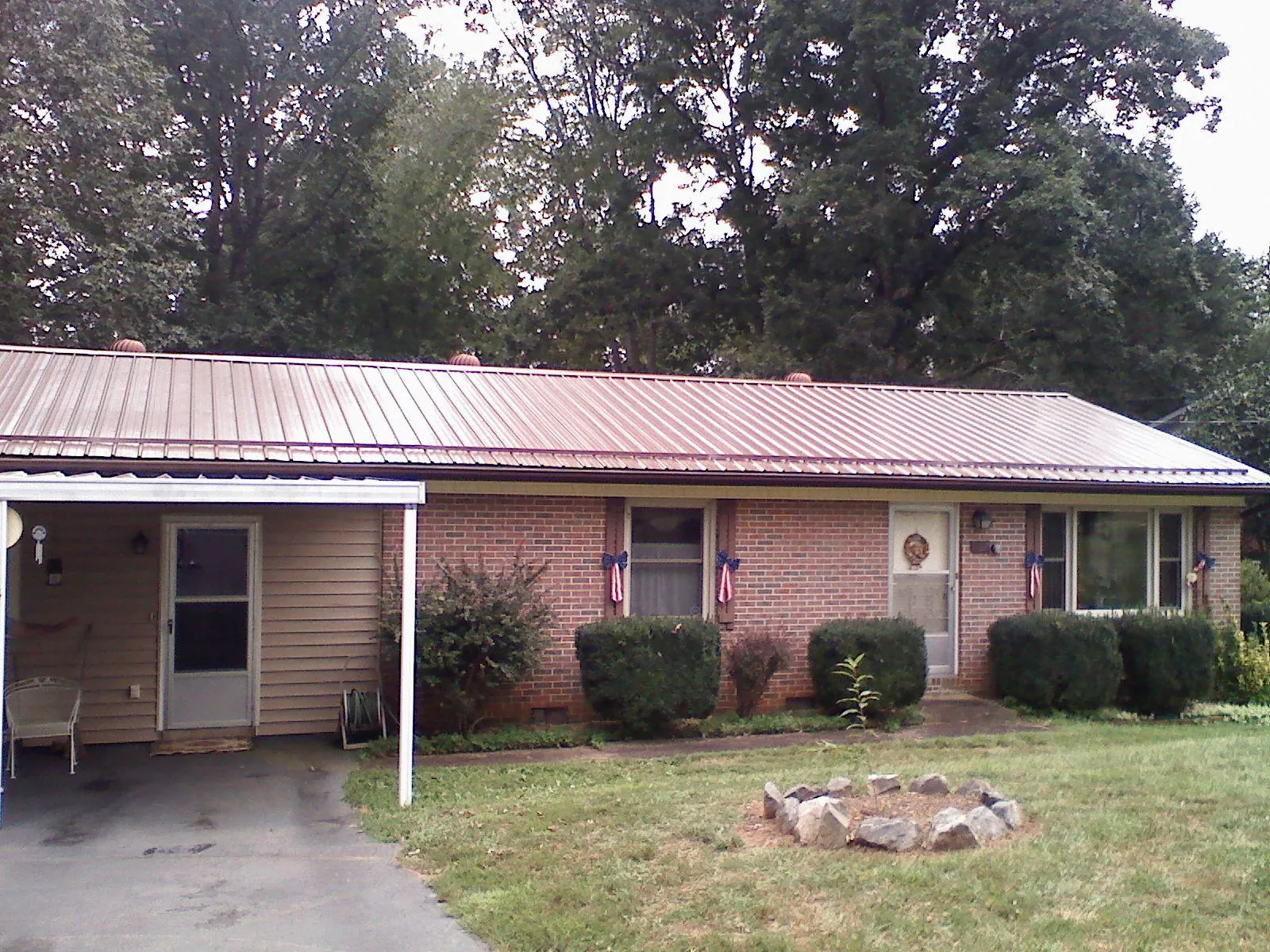 Bronze metal roof and carport on a brick ranch home — Roof Repair work by our crew in Markham